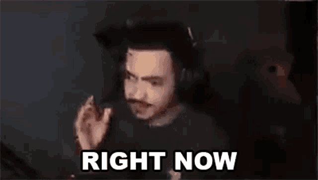 a man wearing headphones is making a funny face while sitting in front of a computer .
