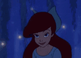 ariel from the little mermaid is wearing a blue dress and a blue bow in her hair .