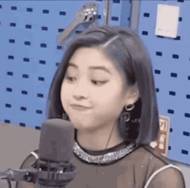 a woman is sitting in front of a microphone in a room .