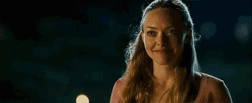 a woman in a pink shirt is making a surprised face