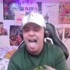 a man wearing headphones and a hat is sticking his tongue out in front of a wall with posters on it