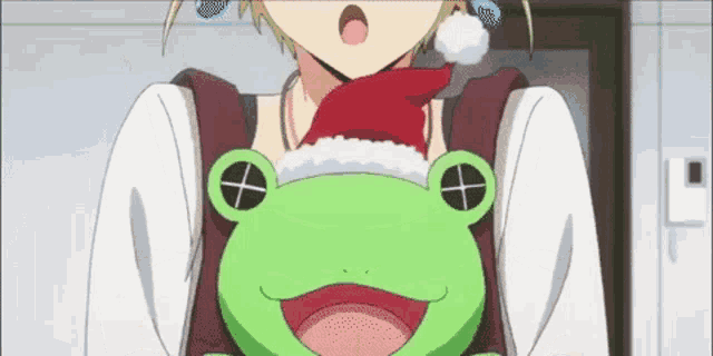 a girl is holding a green frog wearing a santa hat