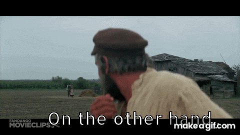a man with a beard is standing in a field and says on the other hand