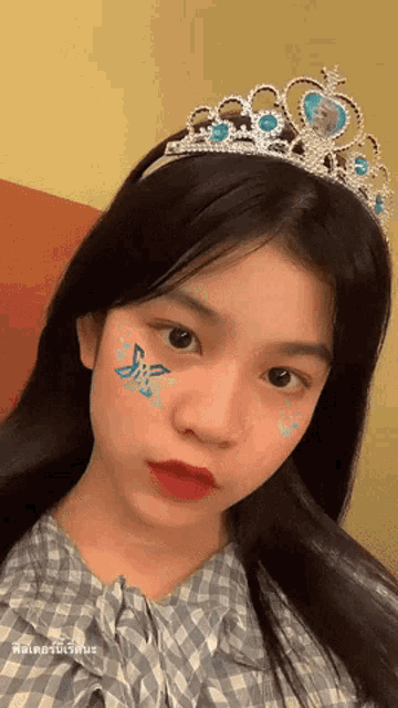 a girl wearing a tiara and a plaid shirt