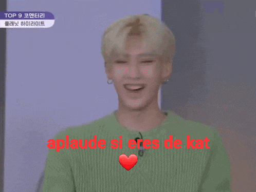 a man in a green sweater says " aplaude si eres de kat " in red letters