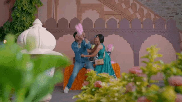 a man and woman are eating cotton candy in front of a building