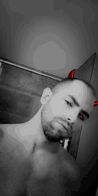 a shirtless man with red eyes and devil horns on his head