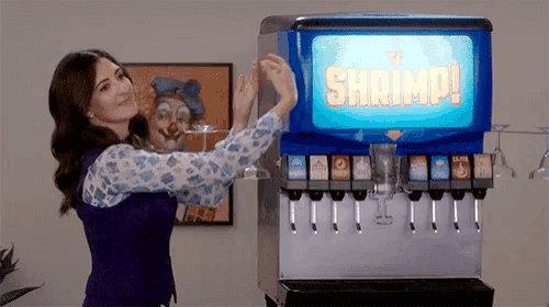 a woman is standing in front of a shrimp soda dispenser