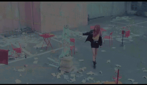 a woman with pink hair is walking down a street in front of a taco bell sign