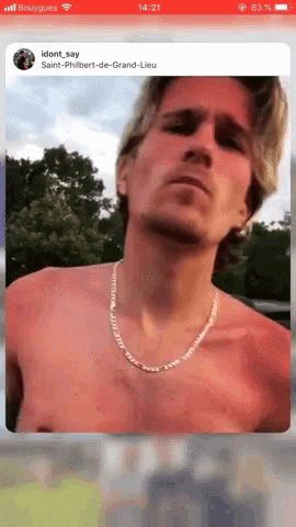 a picture of a shirtless man with a chain around his neck is on a phone screen