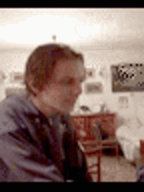 a blurry picture of a man sitting in a living room