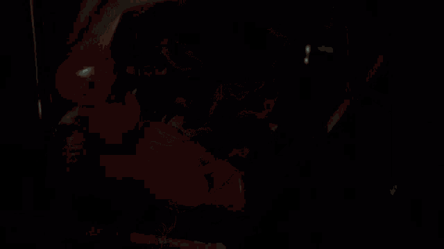 a person is holding a red phone in their hand in a dark room .