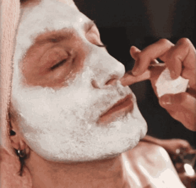 a woman with a white mask on her face is being touched by someone