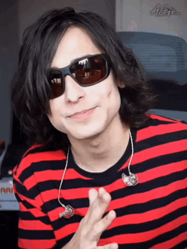 a man wearing a red and black striped shirt and sunglasses