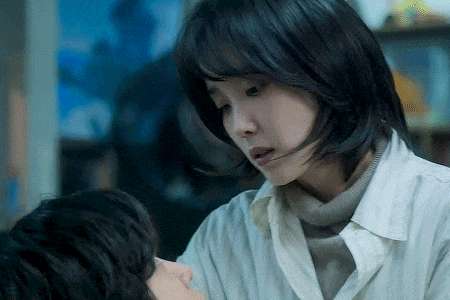 a woman in a white shirt is holding a child 's face .
