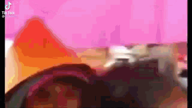 a blurred image of a person 's face with a pink background .