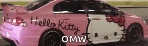 a pink hello kitty car is parked in a parking lot