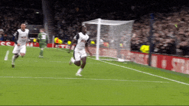 a soccer player wearing a tottenham jersey is running towards the goal