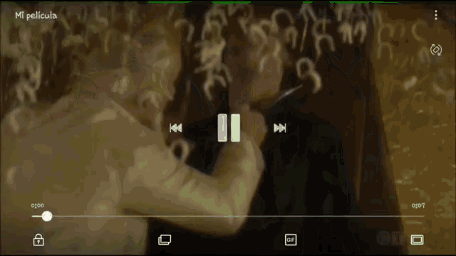 a screenshot of a movie called mi pelicula shows a man holding a knife to another man 's face