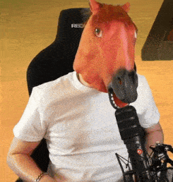 a man wearing a horse mask is sitting in front of a recaro chair