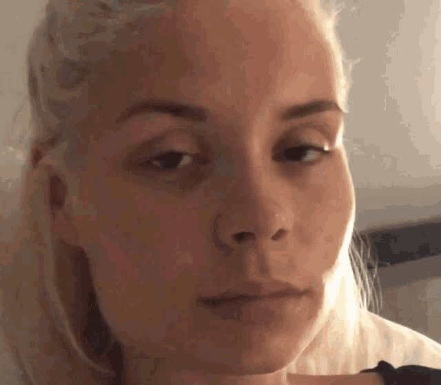 a woman with blonde hair is looking at the camera