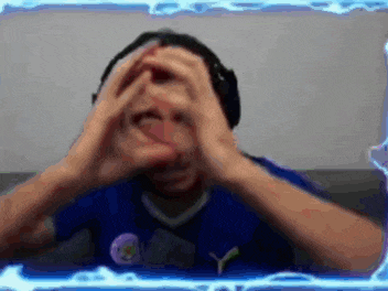 a man wearing headphones is making a heart shape with his hands