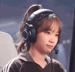 a woman wearing headphones and a microphone is smiling and looking at the camera .