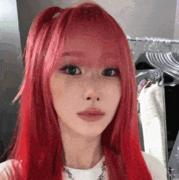 a woman with red hair is taking a selfie in front of a mirror .
