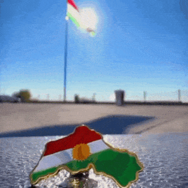 a pin in the shape of the kurdish flag
