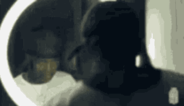 a man is looking at himself in a mirror while wearing sunglasses .