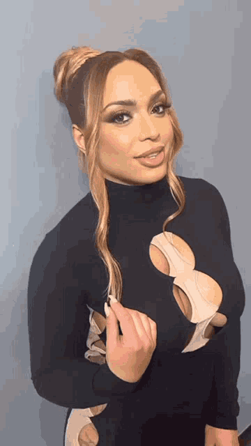 a woman is wearing a black dress with a turtleneck and a plunging neckline .