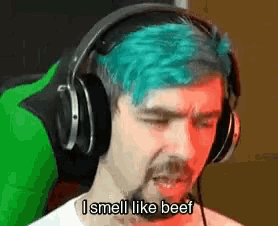 a man with blue hair is wearing headphones and says `` i smell like beef '' .