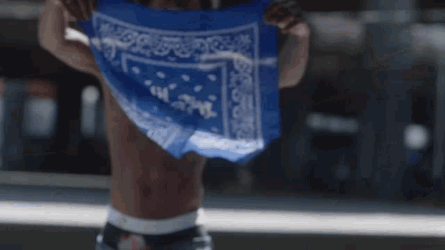 a person holding a blue bandana that says ' i 'm loser '