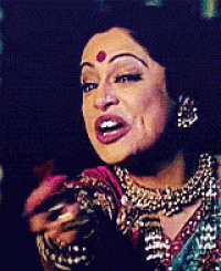 a woman with a red dot on her forehead is wearing a necklace .