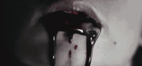 a close up of a woman 's mouth with blood dripping from it .
