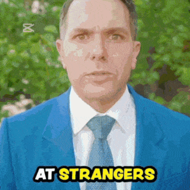 a man in a blue suit and tie says at strangers in yellow letters