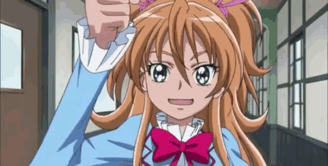 a cartoon girl with long hair and a pink bow is standing in a hallway .