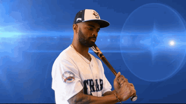 a baseball player is holding a bat with the word trap on his jersey