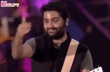 a man is playing a guitar and giving a thumbs up sign .