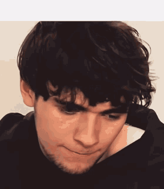 a close up of a man 's face with a beard and a black shirt on .