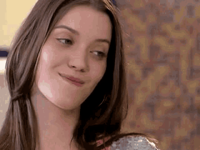 a close up of a woman making a funny face while looking at the camera .