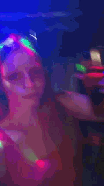 a blurry picture of a woman with purple and blue lights around her face