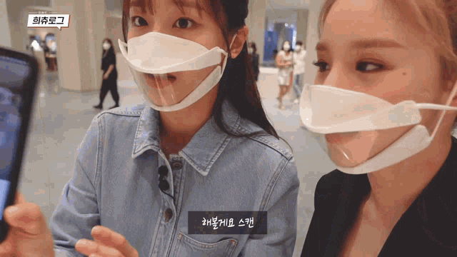two women wearing face masks with chinese writing on the bottom left