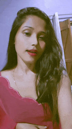 a woman in a pink top is taking a picture of herself
