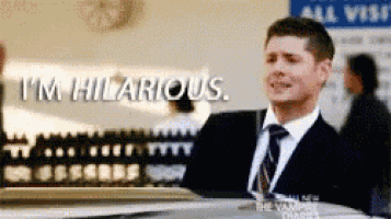 a man in a suit and tie is standing in front of a sign that says i 'm hilarious