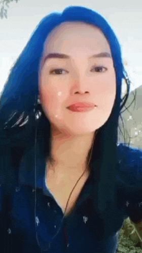 a woman with blue hair is wearing headphones and a blue shirt