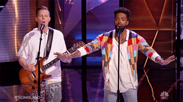 two men singing into microphones with nbc written on the bottom right