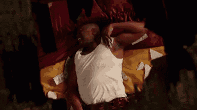 a man is laying on a bed with his arms outstretched and holding a bag of money .