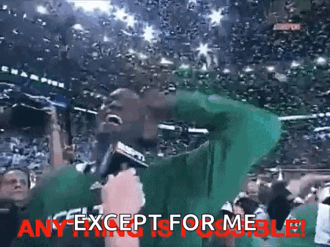 a man in a green shirt is holding a microphone in front of a crowd with the words any except for me visible ..