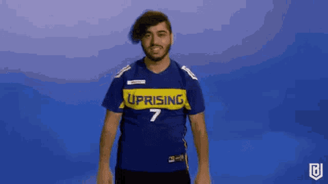 a man wearing a blue shirt with the number 7 on it is dancing on a blue background .
